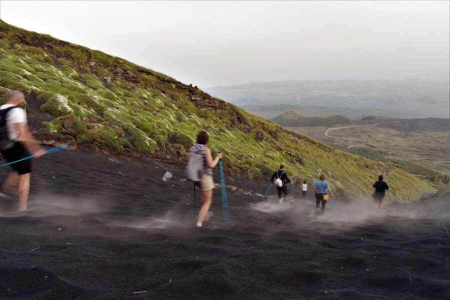 Catania: Etna Morning or Sunset Trek with Lava Tunnel & Gear - Entering a lava tube with helmet and flashlight